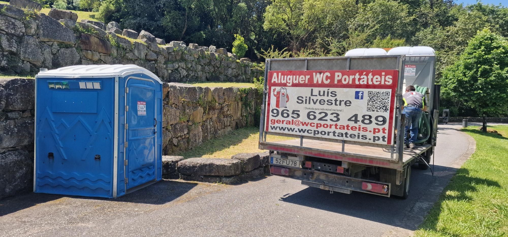 Cabina WC ampla azul e camião da WC Portáteis num parque