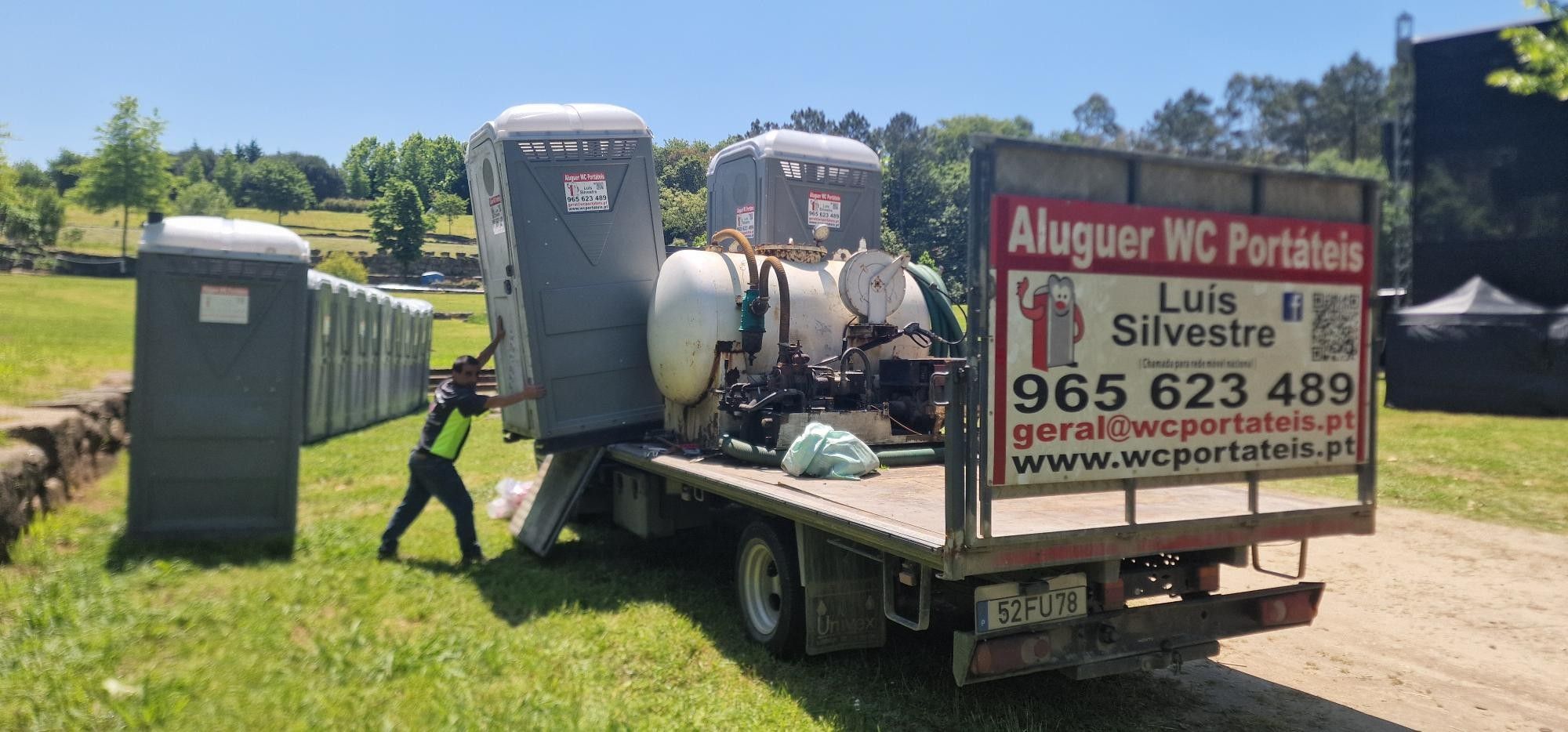Técnico a descarregar um WC portátil do camião num recinto de festival