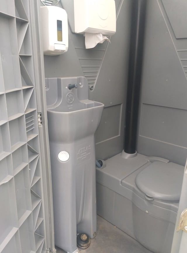 Interior do WC VIP com lavatório, doseador de sabão e toalhas de papel